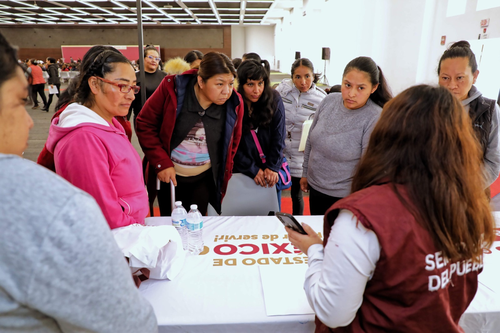 Servidores de la Nación explican los beneficios del programa a una beneficiaria en Toluca.