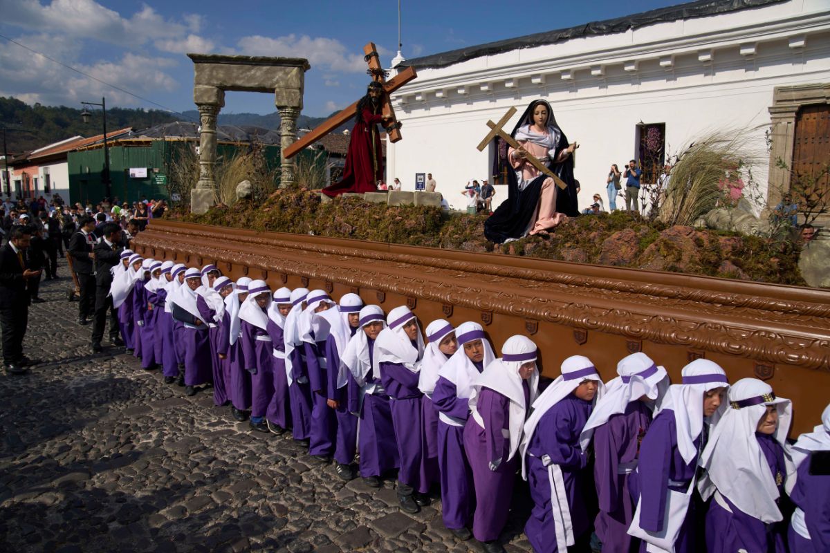 Niños cargan un paso con una imagen de Jesucristo durante una procesión de Semana Santa en Antigua, Guatemala.