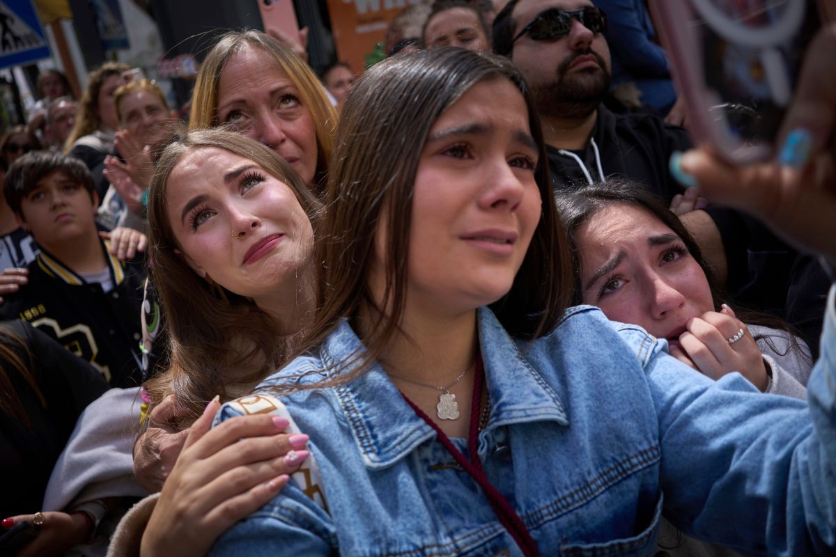 Un grupo de fieles se emocionan durante la procesión del Cristo de la hermandad del Cerro por las calles de Sevilla.