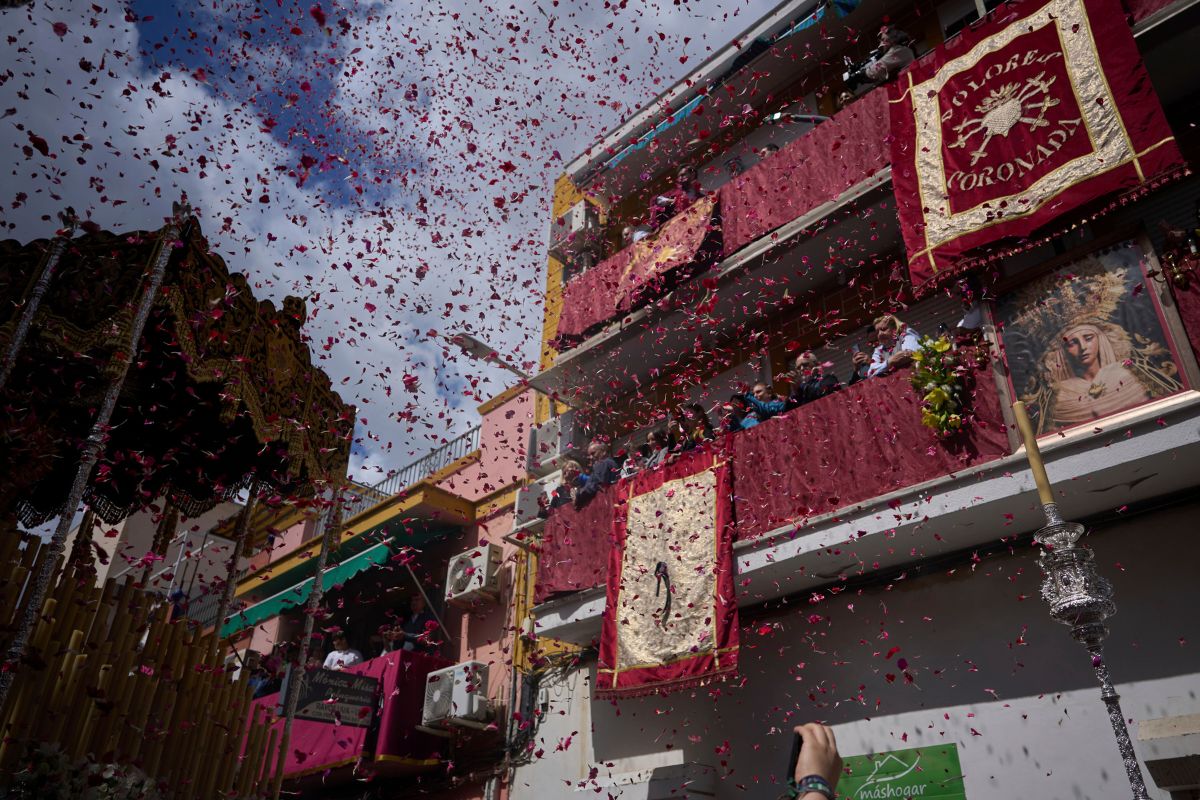 Fieles arrojan pétalos de flores al paso de la Virgen María, durante una procesión de Semana Santa en Sevilla.