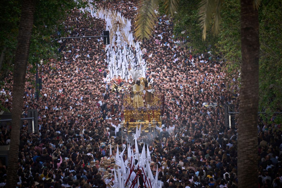 Penitentes de la hermandad de San Gonzalo participan en una procesión de Semana Santa por las calles de Sevilla, España.