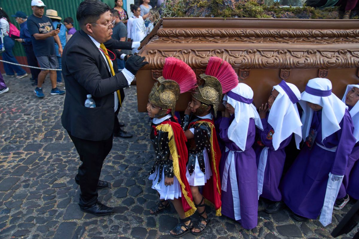 Niños portan una imagen de Jesucristo durante una procesión de Semana Santa en Antigua, Guatemala.