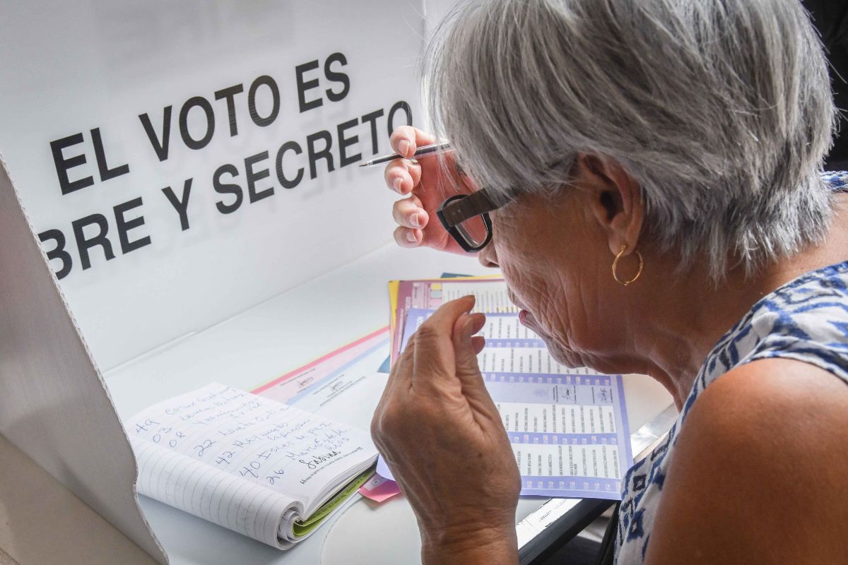 Una adulto mayor se respalda con un acordeón escrito por ella misma para decidir y emitir su voto en la boleta adecuada en las elecciones del Poder Judicial. Foto: Cuartoscuro