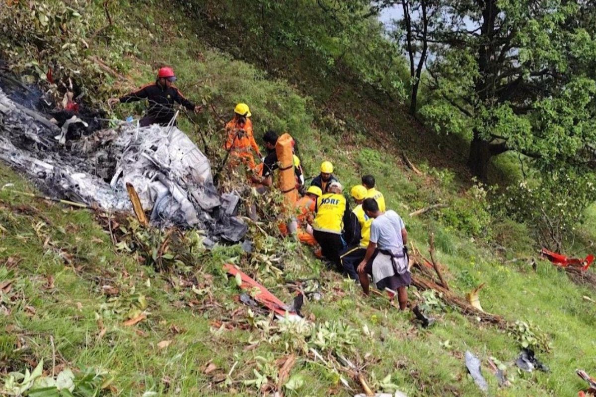 Rescatistas indios trabajan entre la maleza para recuperar cuerpos tras la caída de la aeronave. Foto: Especial