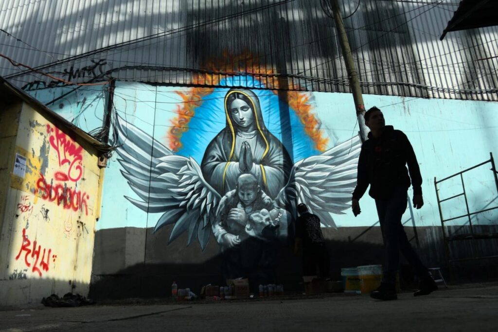 Transeúntes observan la obra que recuerda a 'La Abuelita Heroína'. Foto: Especial